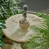Auf einem Brunnen steht die Figur eines kleinen Jungen.